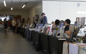 a row of authors and book sellers at the COC Book Fair.